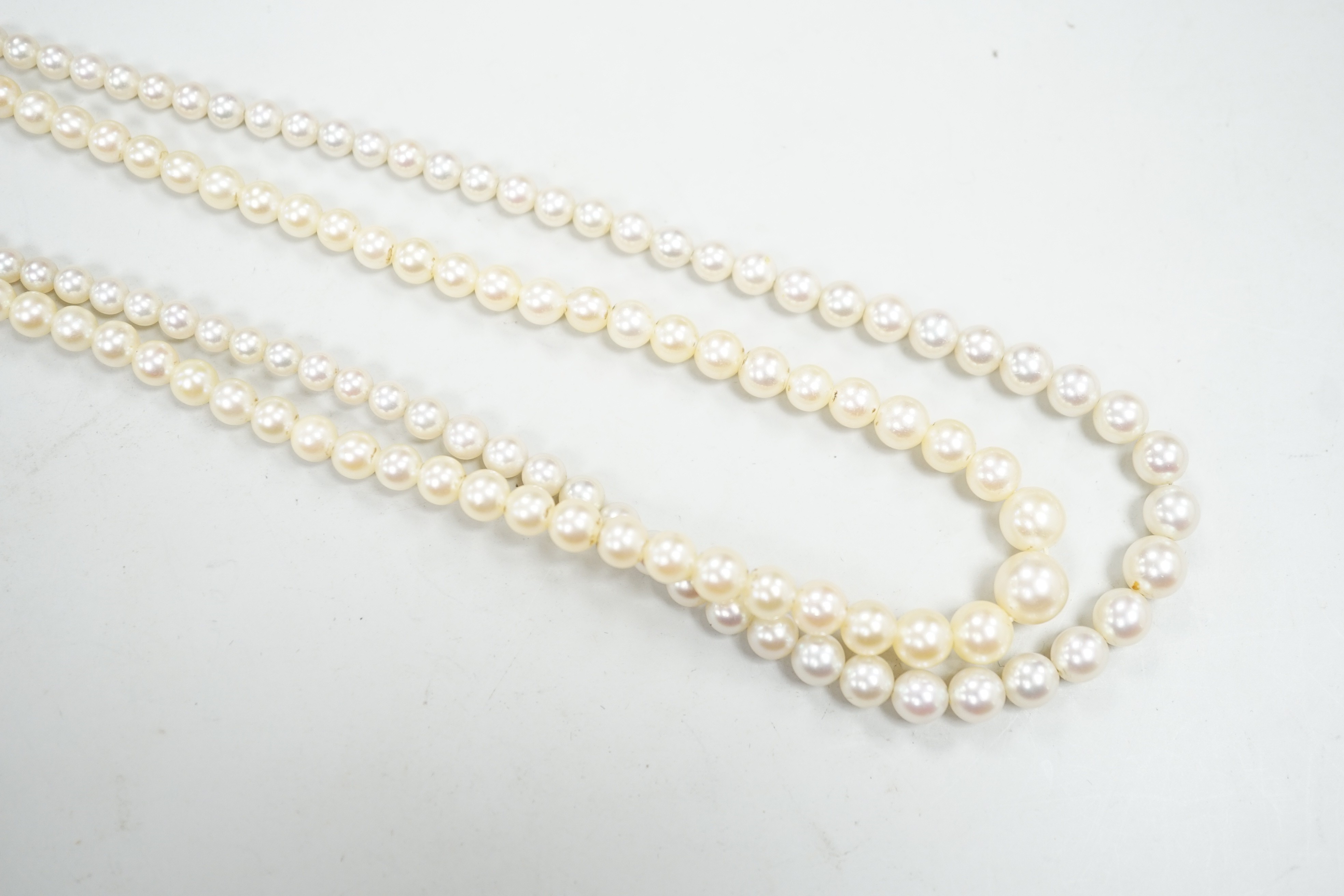 Two single strand graduated cultured pearl necklaces, both with diamond set white or yellow metal clasps, 39cm and 44cm.